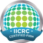IICRC Certified Firm logo showing a circular design of green and blue dots, surrounded by a silver border, with a blue ribbon at the bottom displaying the text "IICRC CERTIFIED FIRM.